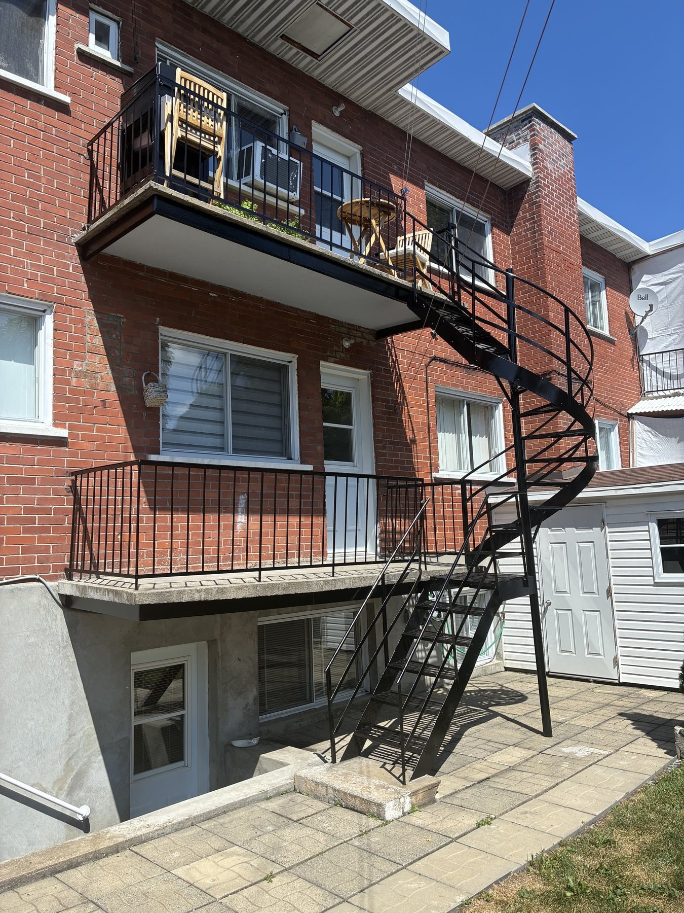 Balcons et escalier en colimaçon en fer forgé sur une maison de brique
