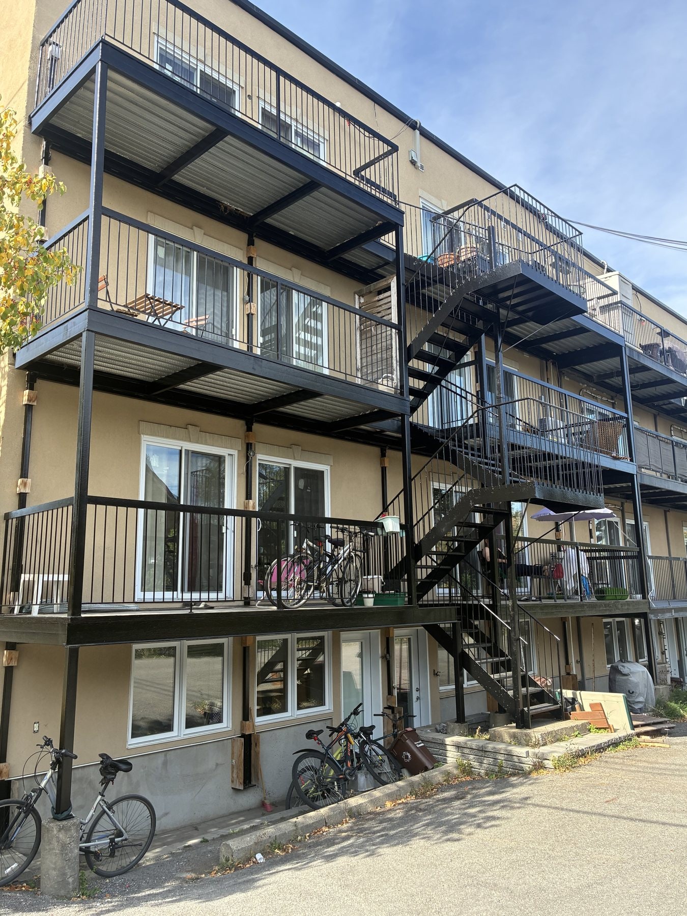 Balcons et escaliers en fer forgé repeints sur un immeuble de trois étages