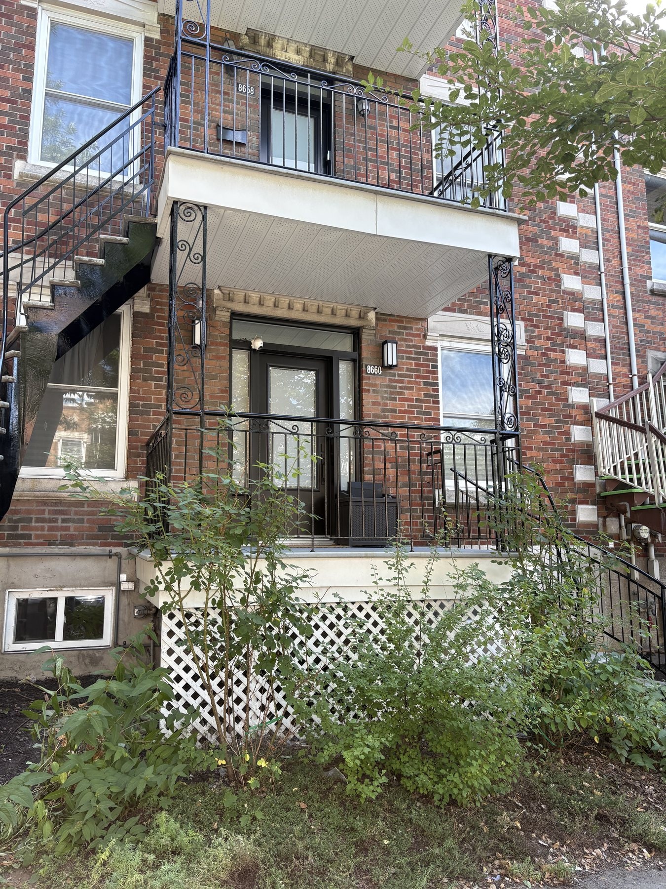Balcons et garde-corps en fer forgé sur une façade de brique