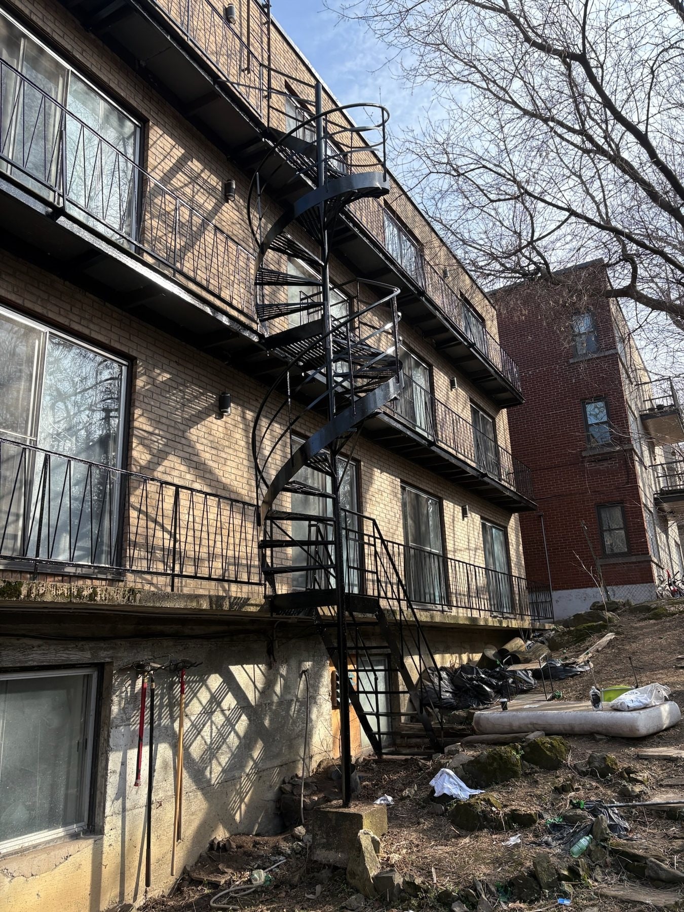 Escalier en colimaçon et balcons en fer forgé repeints à l'arrière d'un immeuble