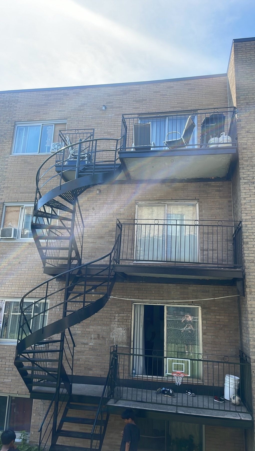 Escalier en colimaçon et balcons en fer forgé sur un immeuble de trois étages