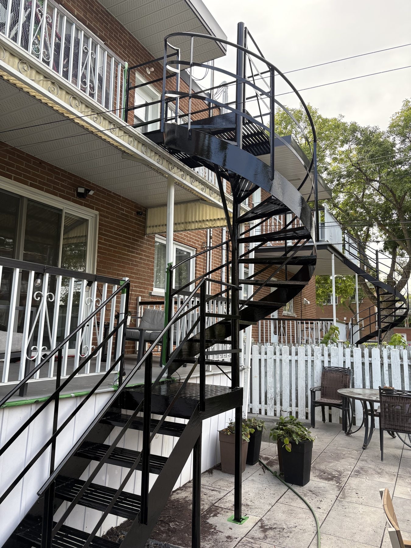 Escalier en colimaçon et escalier droit en fer forgé au-dessus d'une terrasse