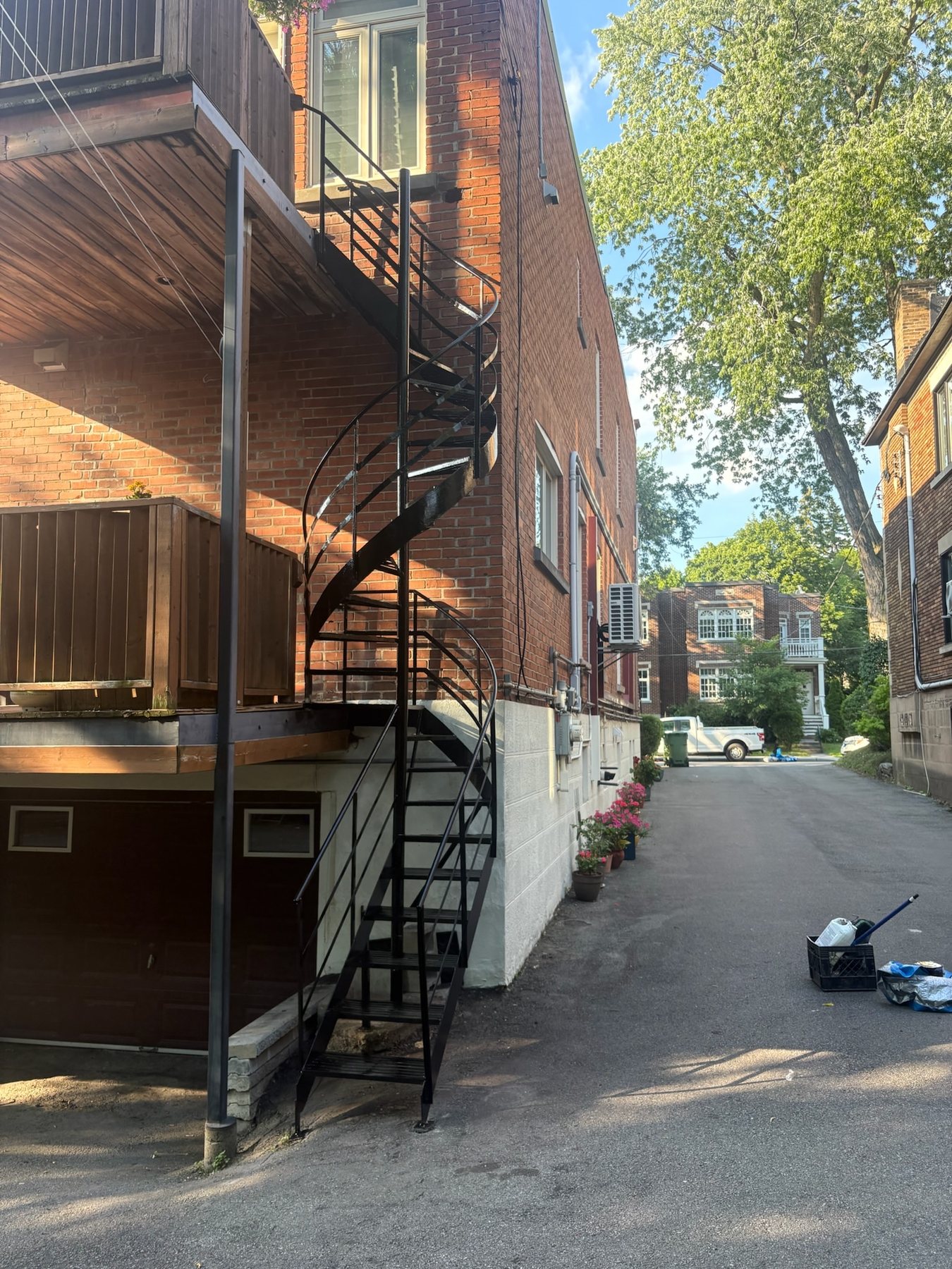 Escalier en colimaçon en fer forgé noir donnant sur une ruelle