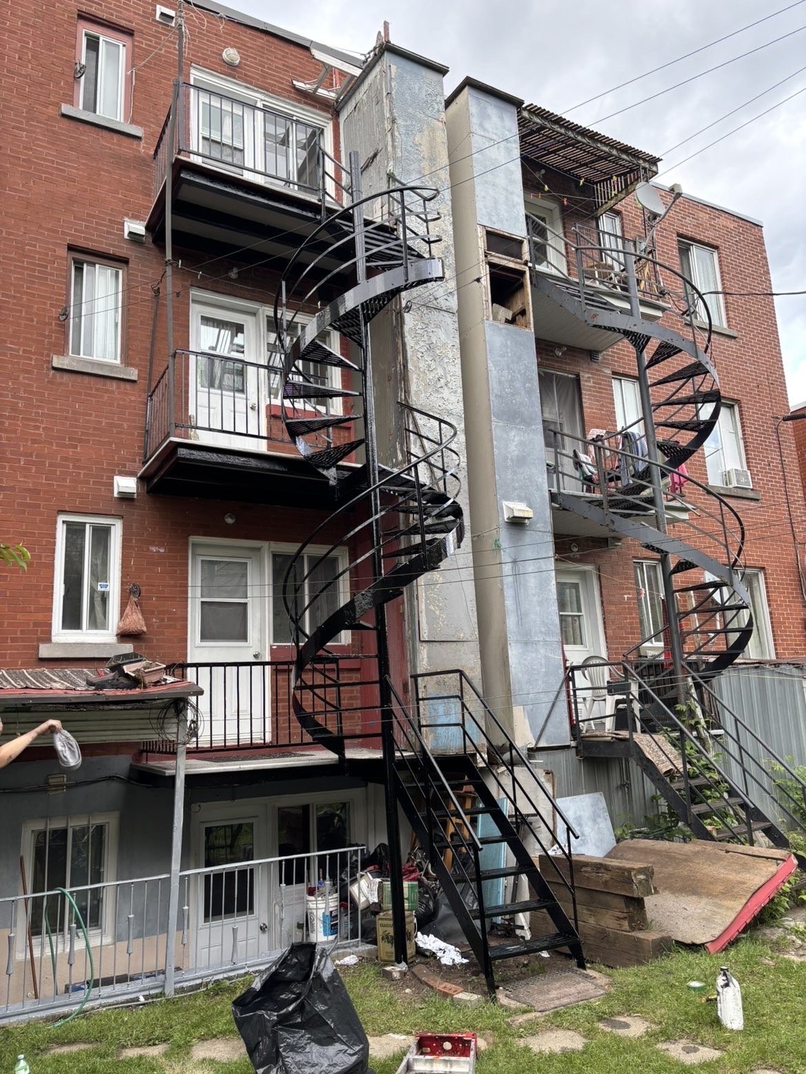 Deux escaliers en colimaçon en fer forgé sur un immeuble de brique de quatre étages