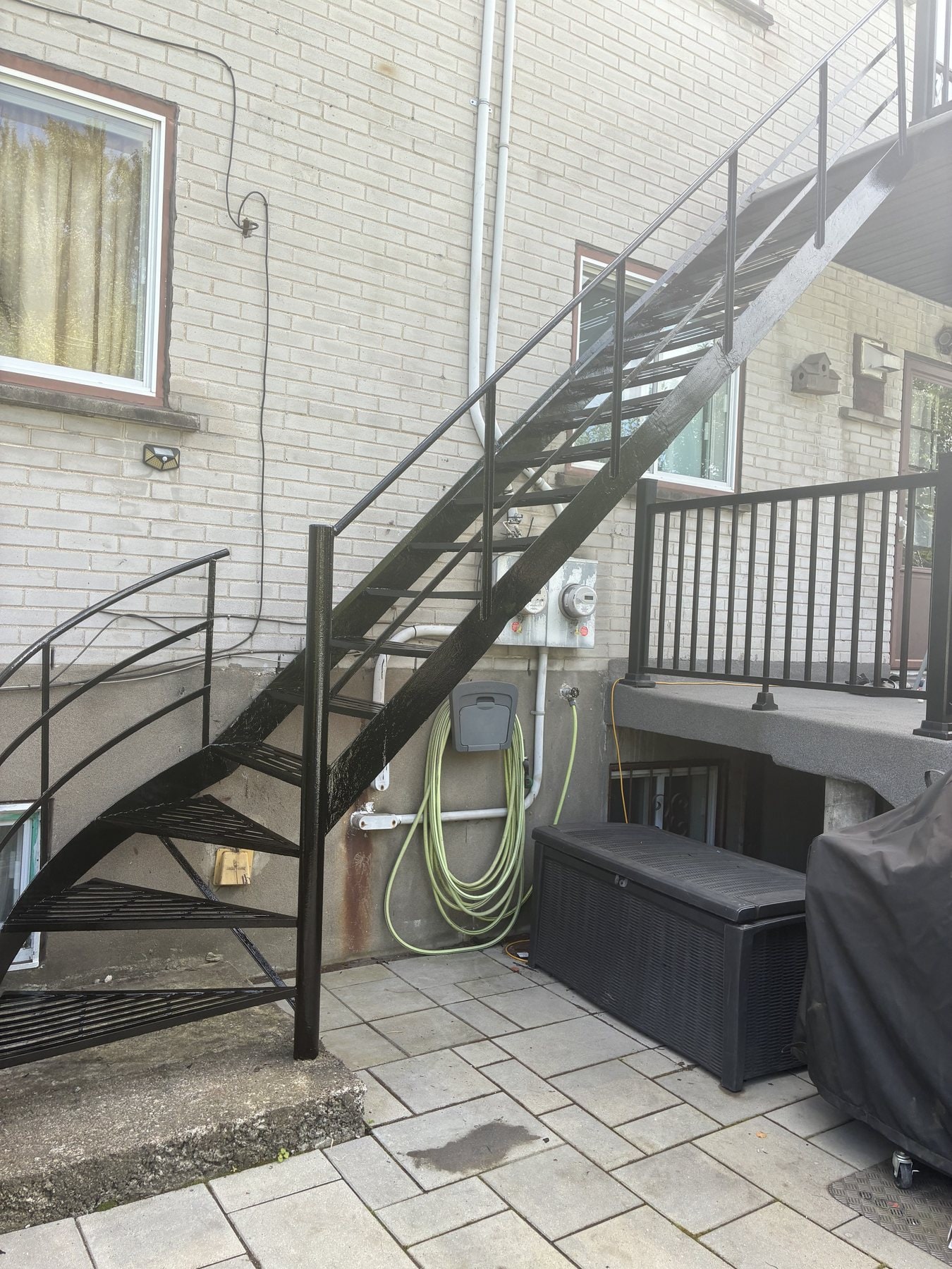 Escalier droit en fer forgé noir au-dessus d'un patio