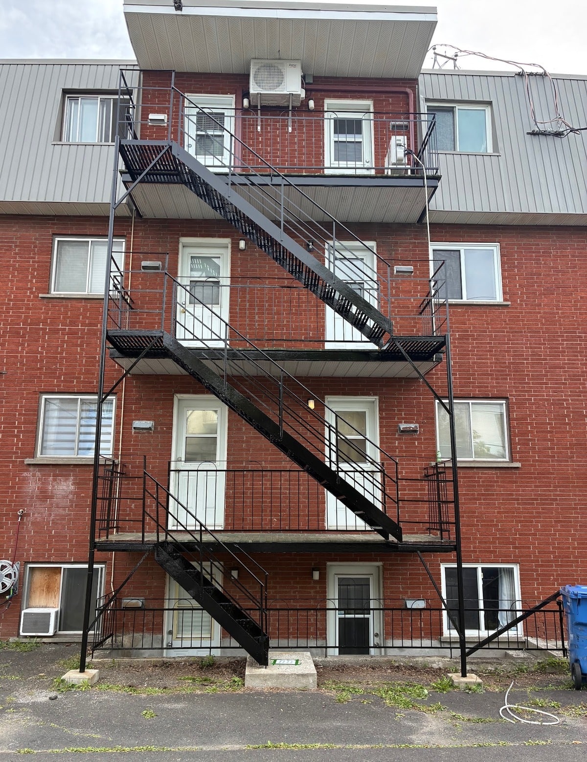 Escalier de secours de trois étages sur un immeuble de brique rouge, après les travaux