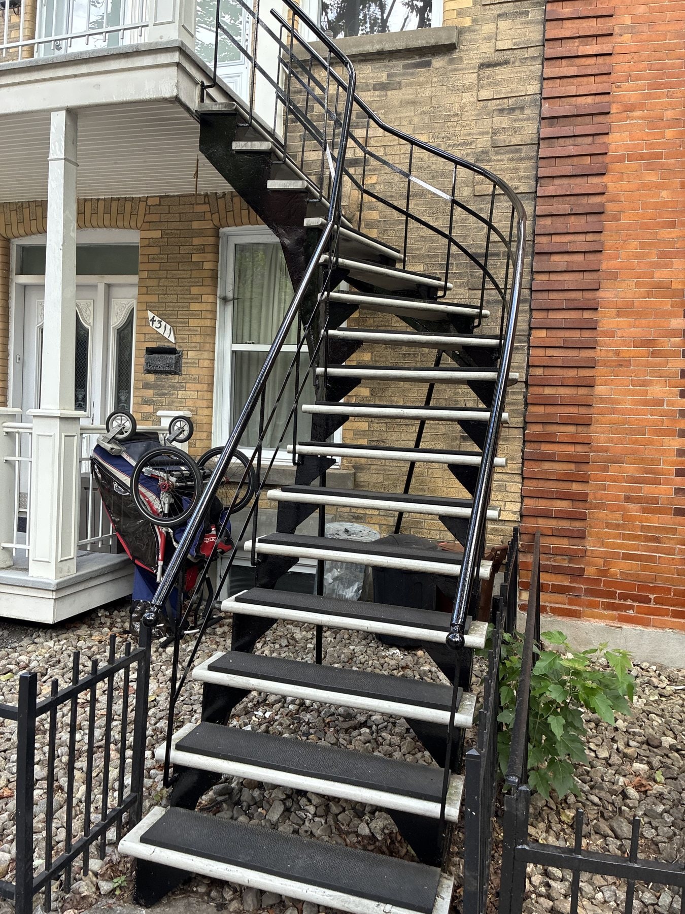 Escalier tournant en fer forgé noir à l'avant d'une maison