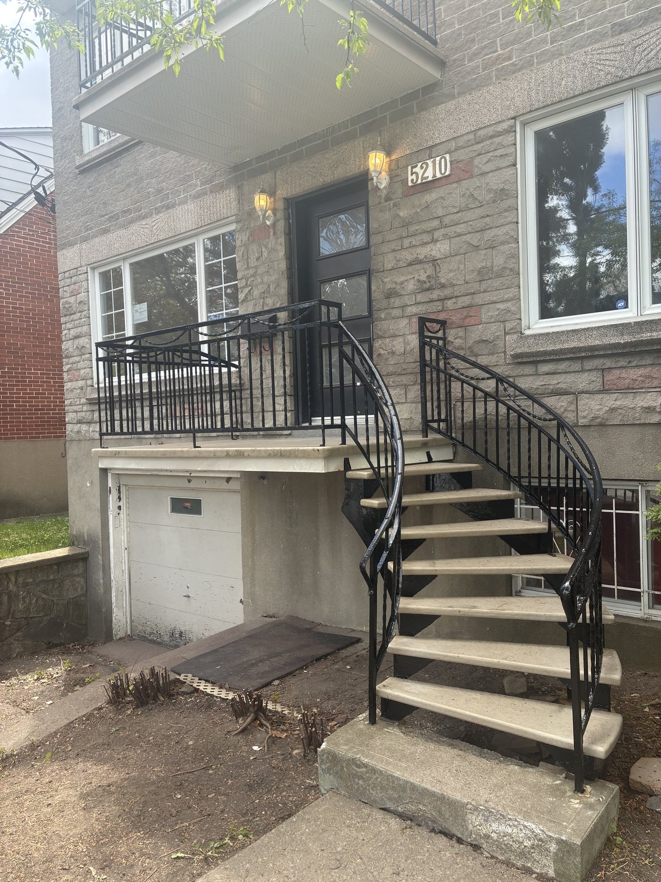Escalier tournant en fer forgé noir au-dessus d'un garage