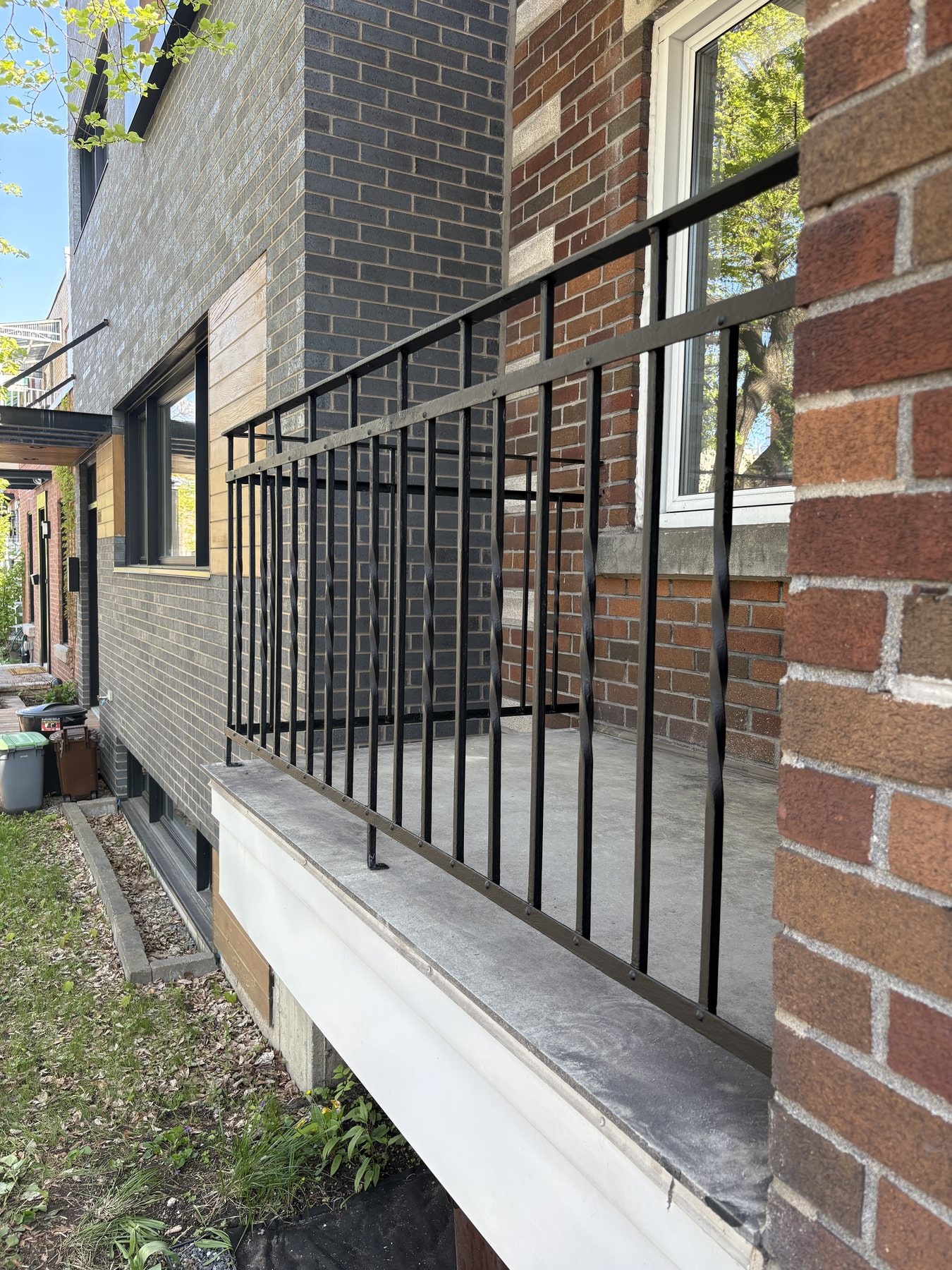 Garde-corps en fer forgé noir le long d'un balcon de béton