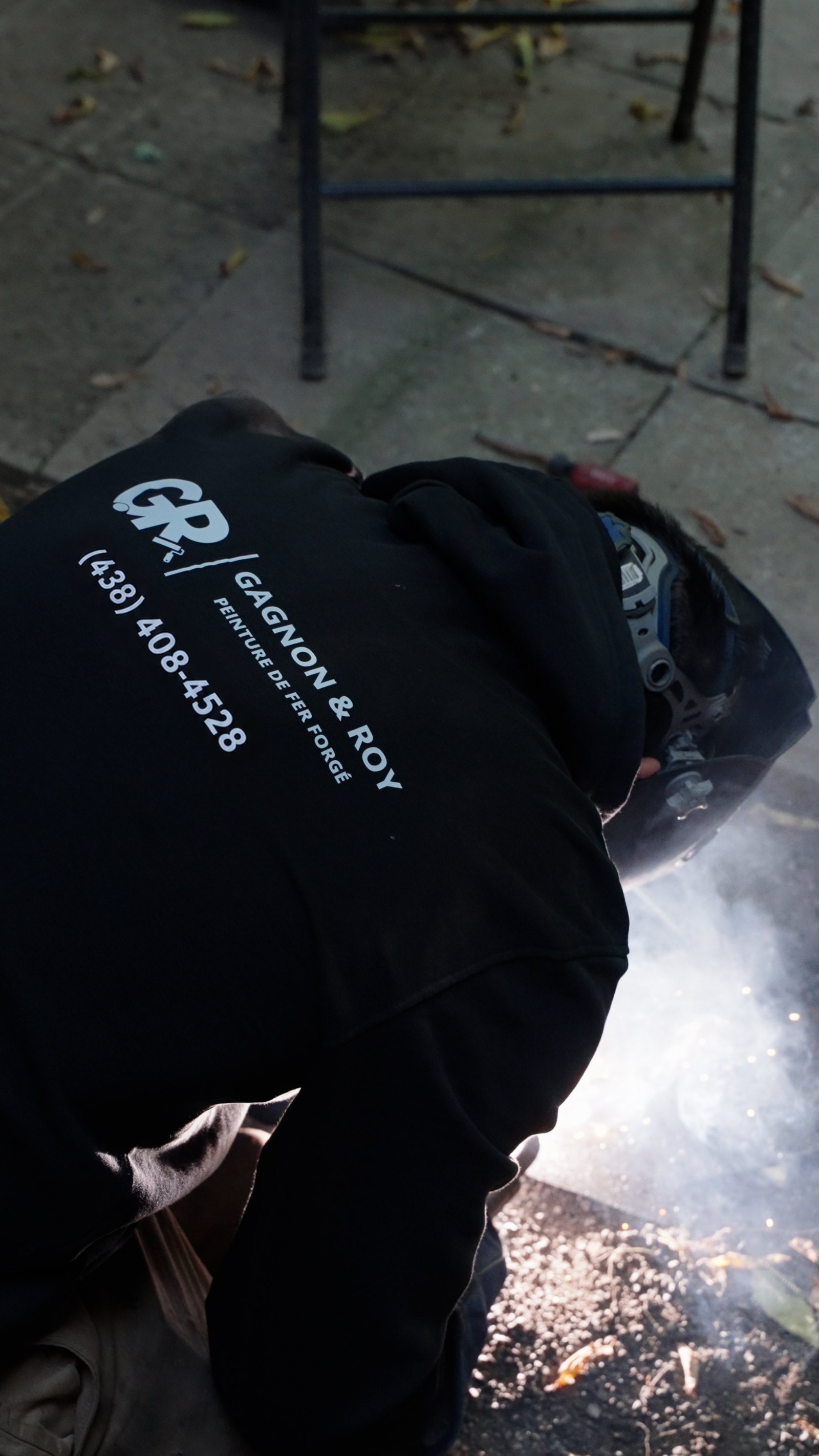 Soudeur de Peinture GR, logo et numéro au dos du chandail, en pleine soudure de fer forgé