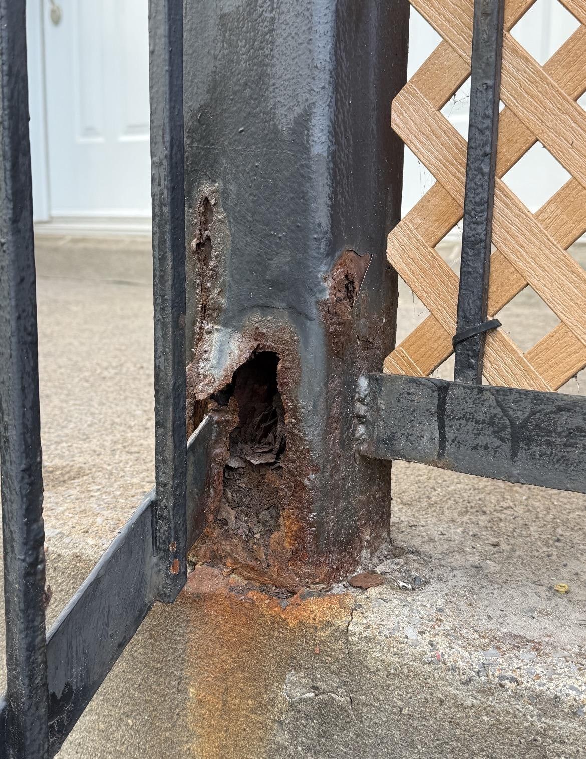 Poteau de rampe en fer forgé percé par la rouille, réparé par soudure puis repeint, avant les travaux